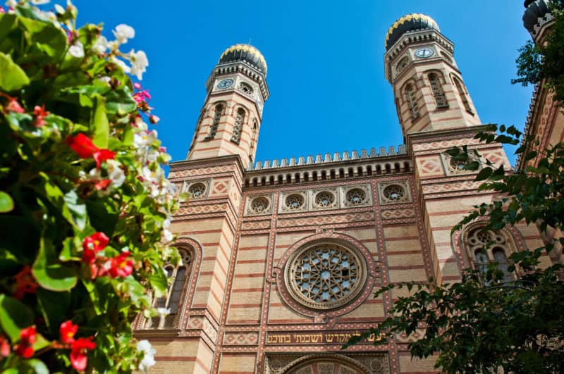 The imposing towers of the Great Synagogue framed by garden flowers