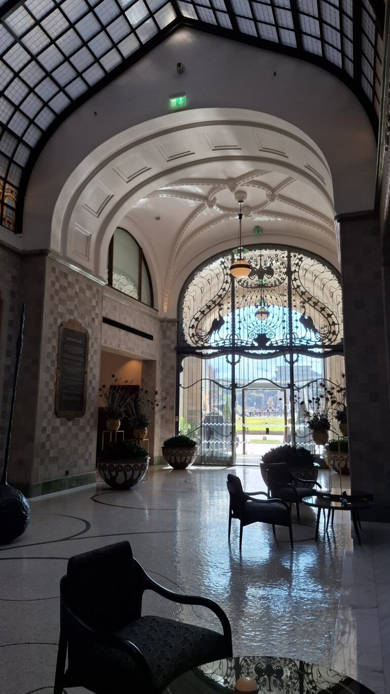The highly ornate, golden wrought-iron peacock gates at the entrance of the Gresham Palace
