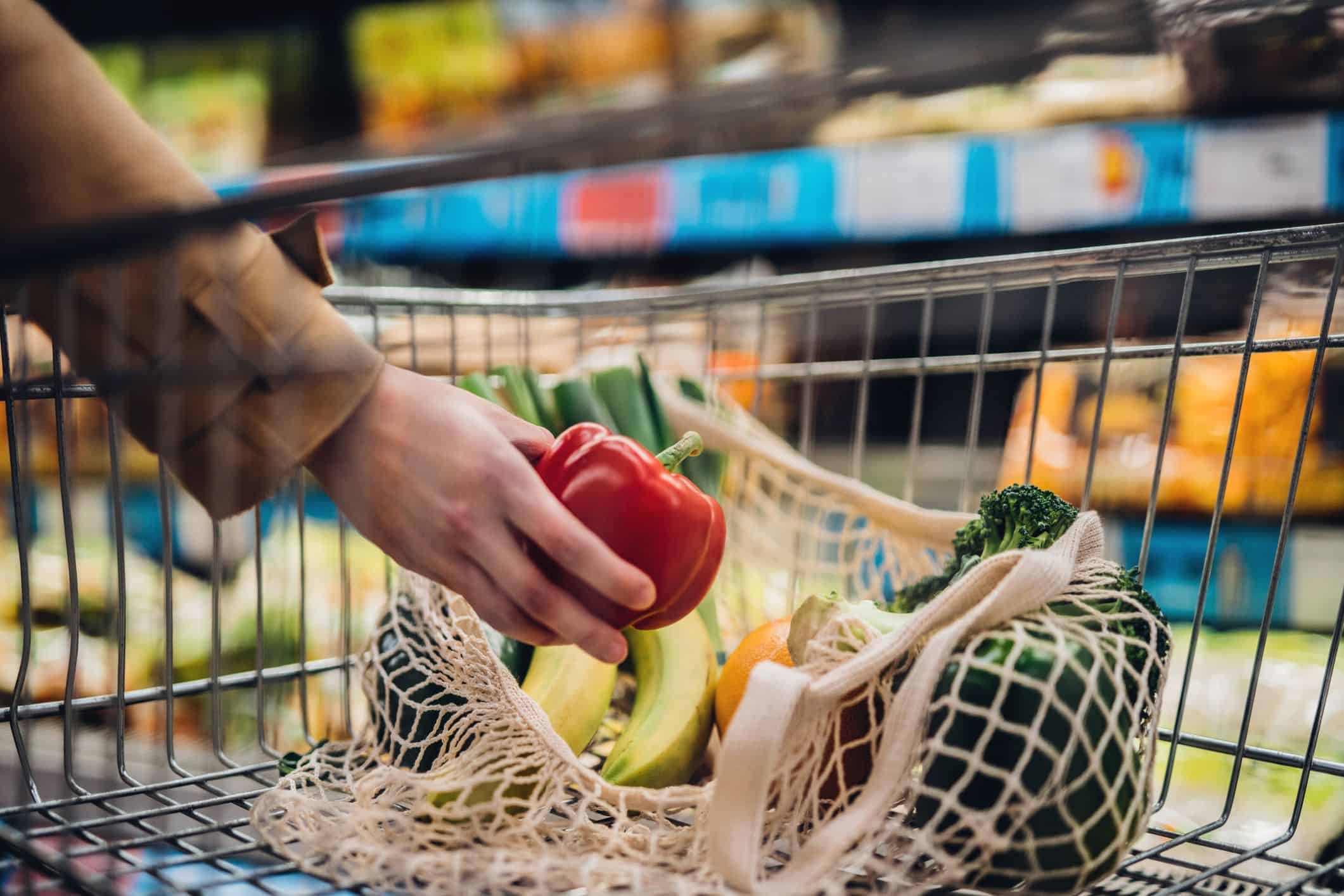 A customer using a reusable bag for fresh vegetables in a Budapest store