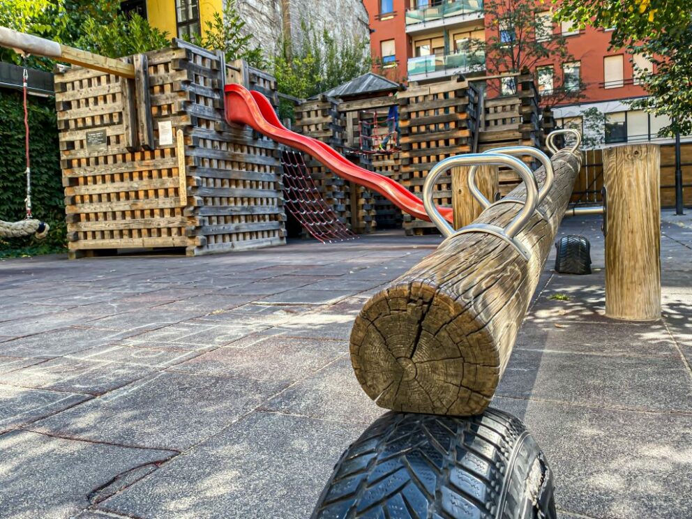 A large, secure wooden children's playground built directly inside the Grund courtyard