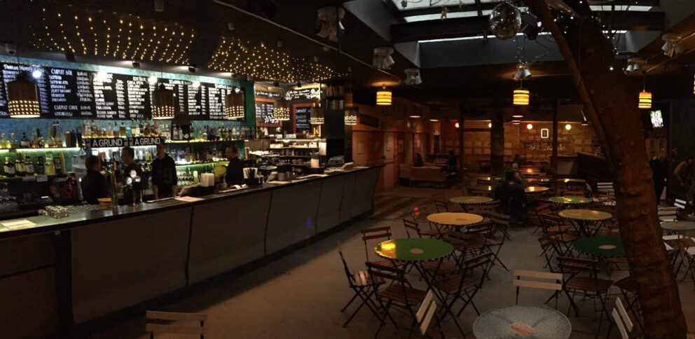 The well-lit, wooden main bar counter inside Grund showcasing draft beer taps