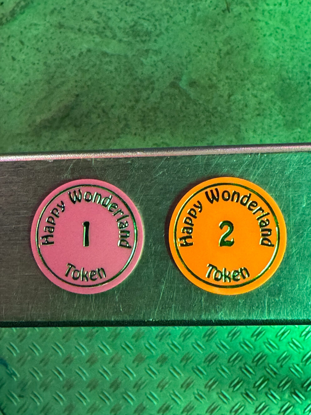 A handful of brightly colored plastic ride tokens used at Happy Wonderland