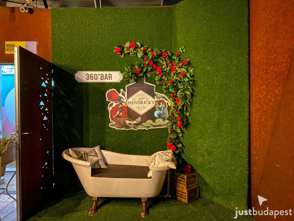 Instagram photo spot with a bathtub sofa and Hendrick's Gin logo against a floral green wall