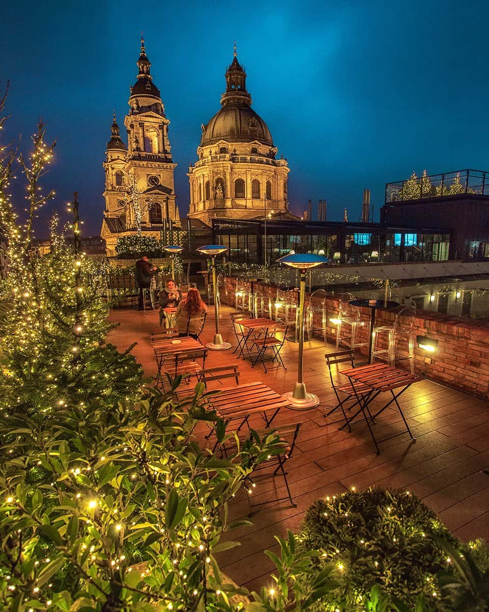Two cocktails on a table at High Note SkyBar with a massive view of the lit Basilica dome