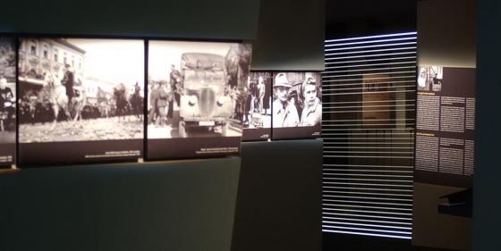 Large illuminated informational displays and historic footage inside the dark museum