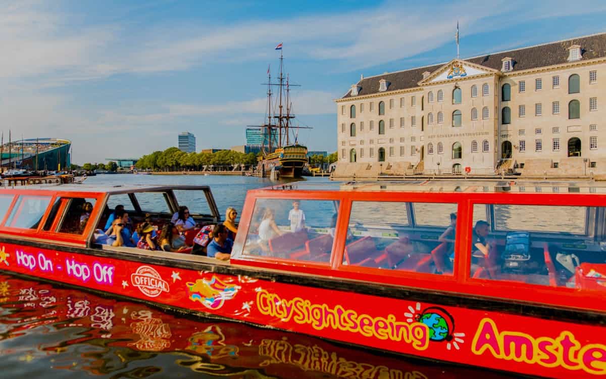 Tourists boarding a hop-on-hop-off sightseeing boat at a pier on the Danube
