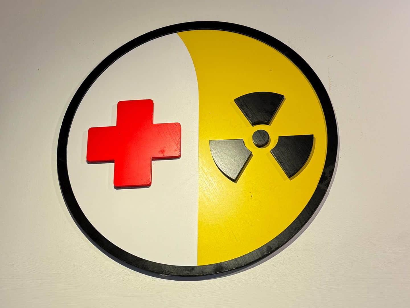 The logo of the museum combining a red cross and a nuclear bunker symbol