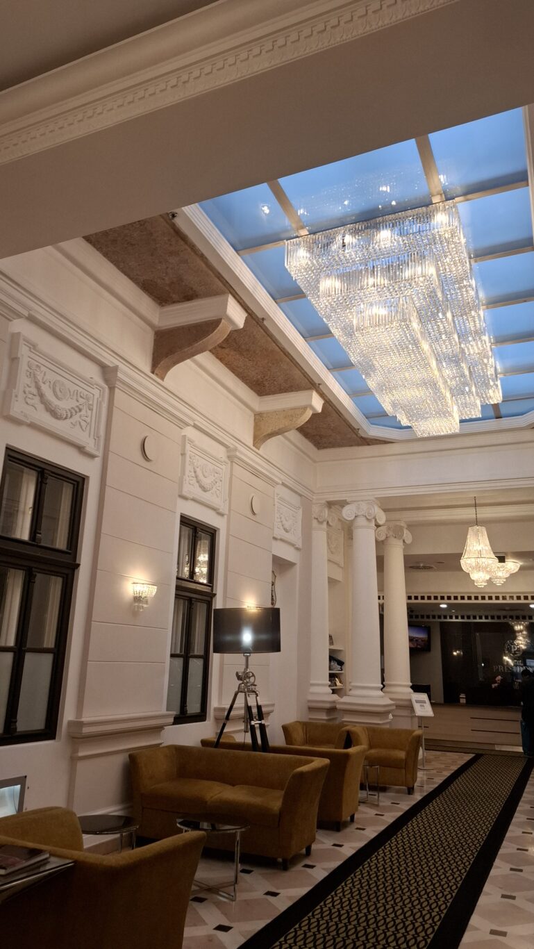 The elegant lobby seating area beneath a massive crystal chandelier