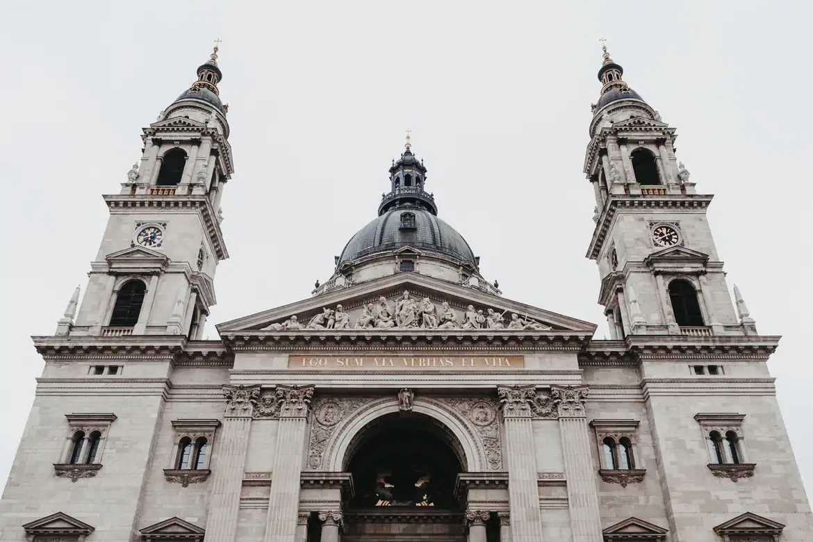 A daytime view across the Danube River towards the intricately detailed Parliament building