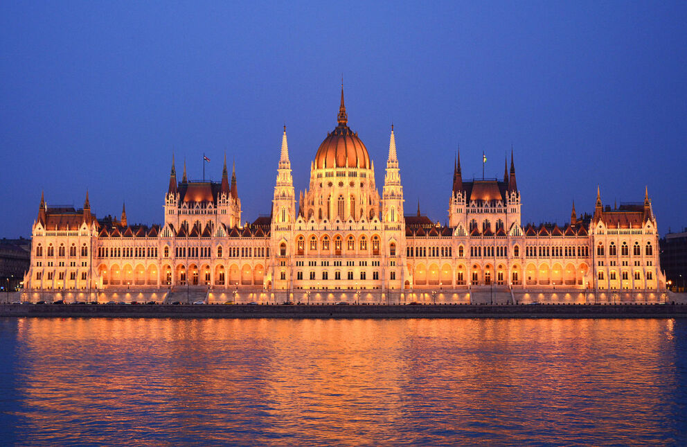 The illuminated Hungarian Parliament Building reflecting in the Danube at night
