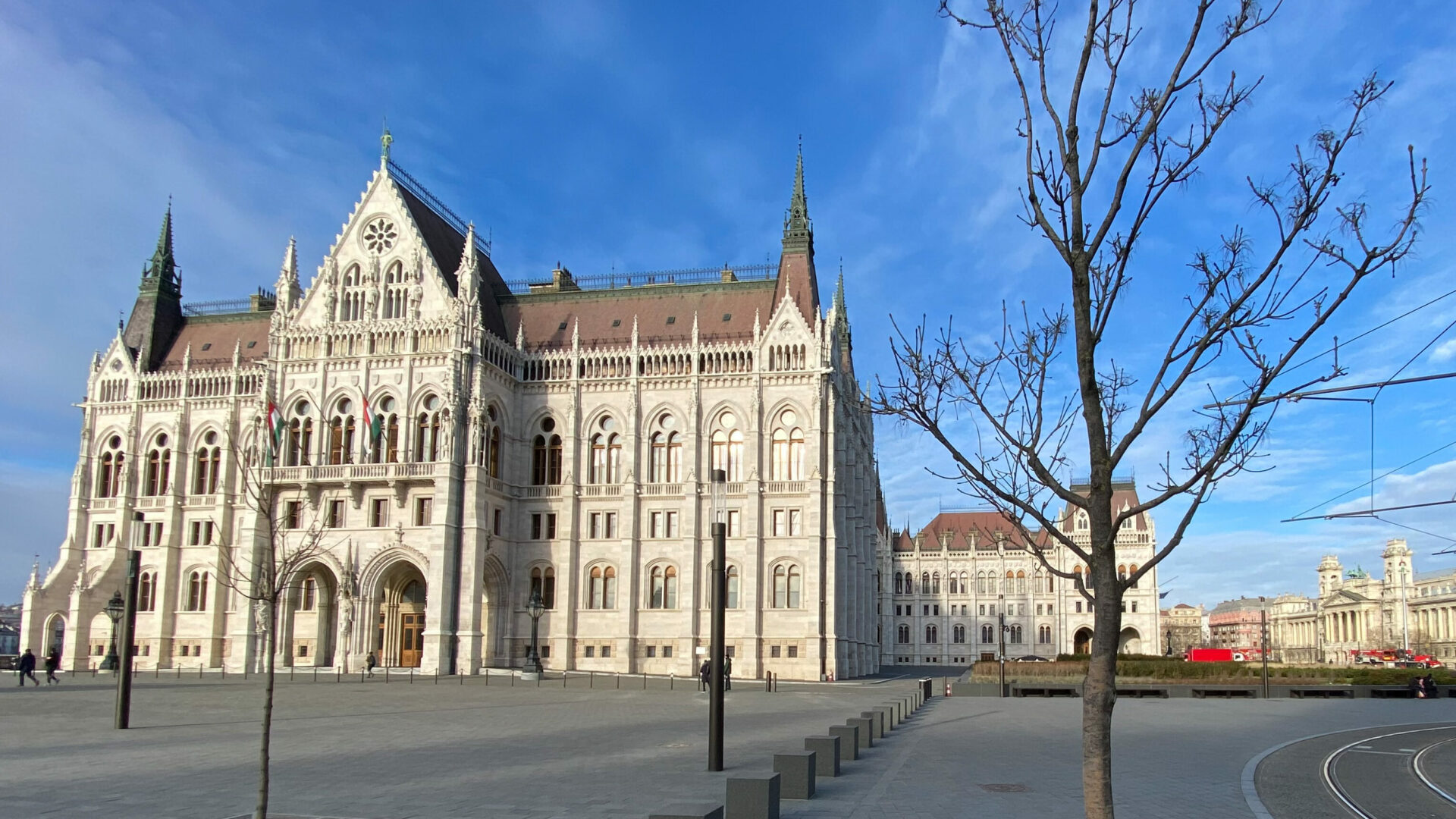 The grand white facade of the Hungarian Parliament on a crisp winter day