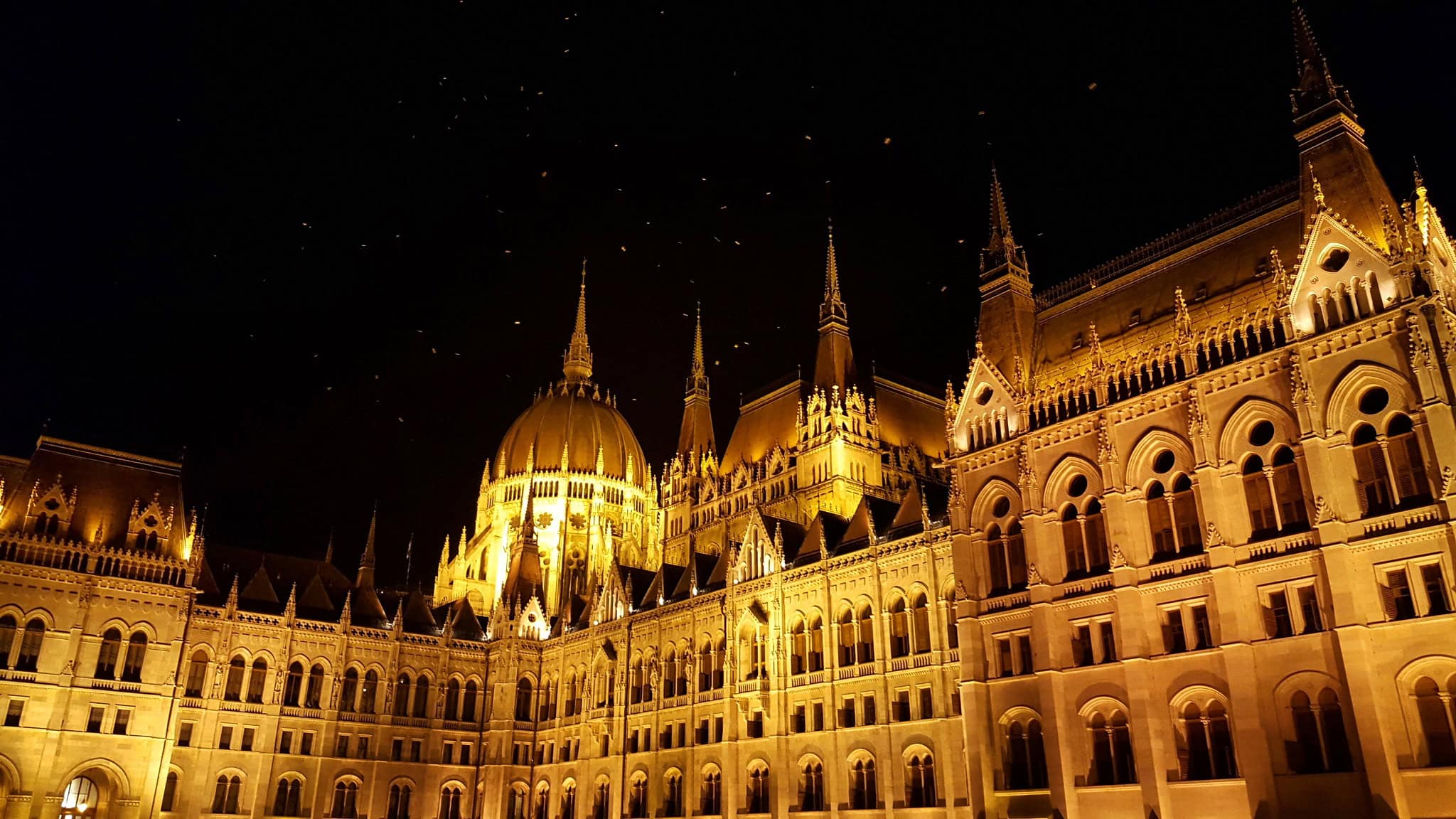 The brilliantly lit Hungarian Parliament building reflecting in the Danube at night
