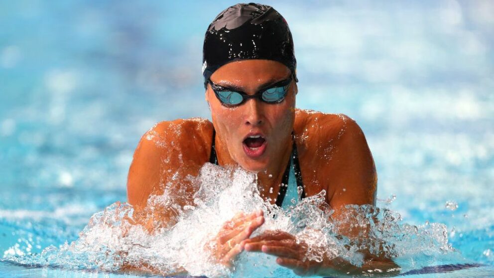 A female swimmer taking a breath during a competitive race