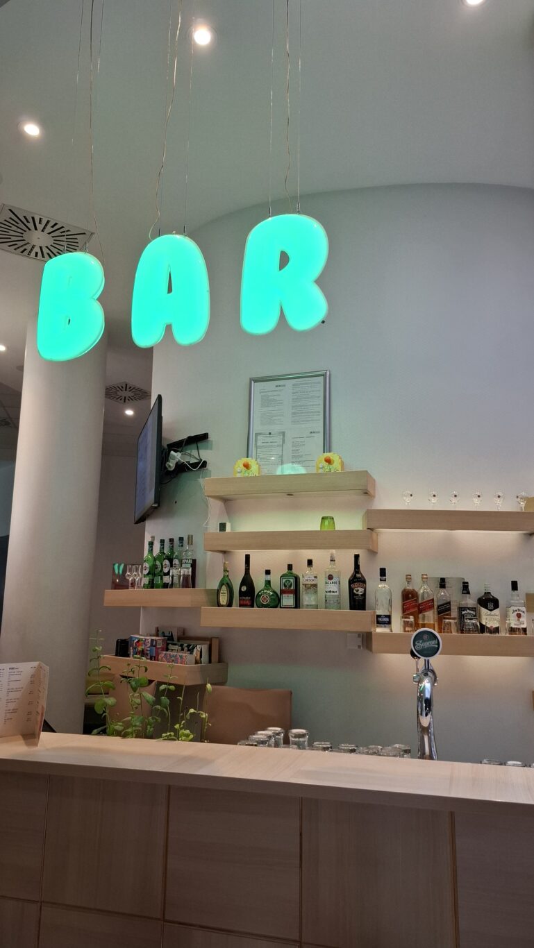 The wildly vibrant, neon-yellow hotel reception desk featuring pixel-art Space Invaders