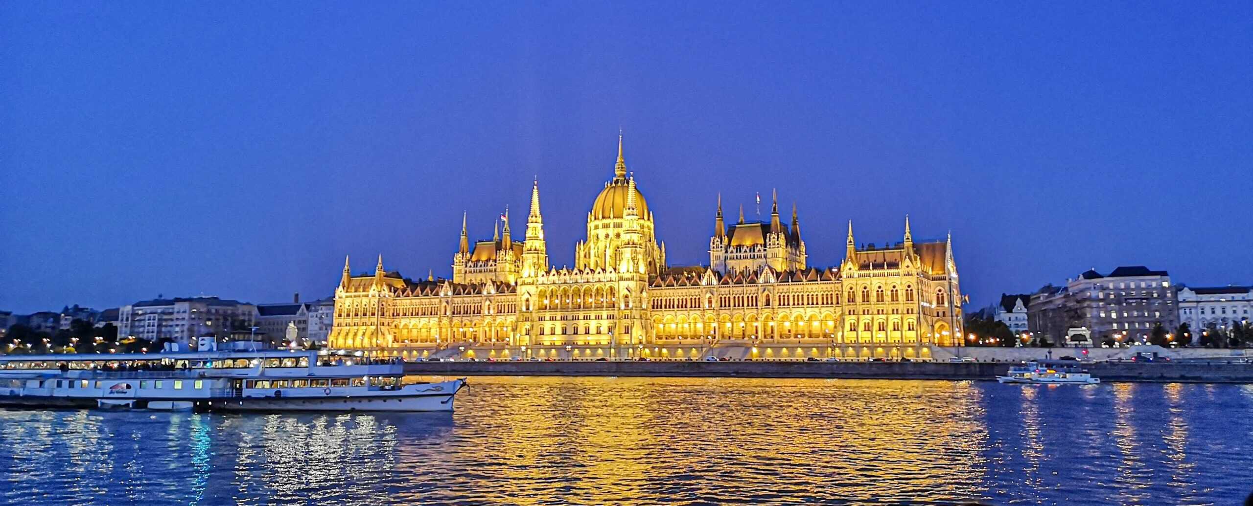 A nighttime view of the brilliantly illuminated Hungarian Parliament taken from a riverboat