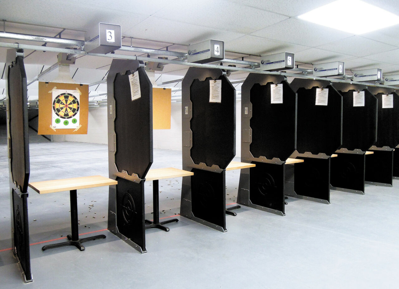 Modern indoor firing lanes separated by black partitions at a Budapest range