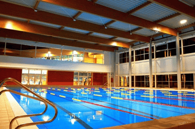 A modern indoor swimming pool divided into lanes for lap swimming