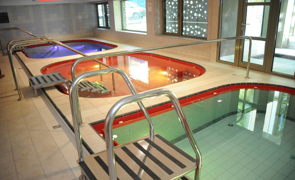 The modern, brightly lit indoor thermal healing pool inside Csillaghegyi Bath
