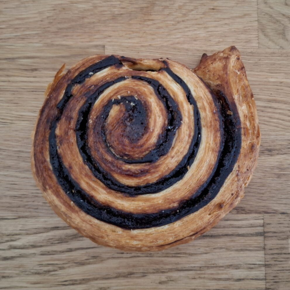 A fresh, flaky Kakaós Csiga pastry oozing with rich dark cocoa spirals