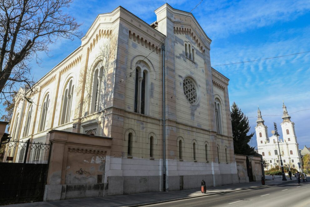 The pale yellow brick facade of the Kazinczy Street Synagogue viewed from the street