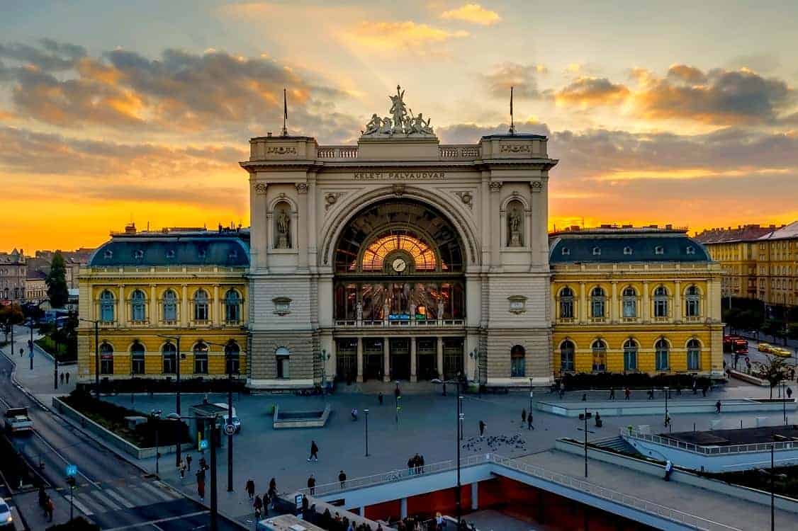Waiting trains parked at the platforms under the massive iron roof inside Keleti Station