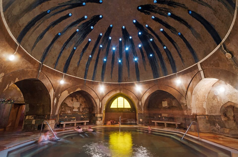 The dark, wildly atmospheric, heavily steaming central octagonal pool inside Király Bath