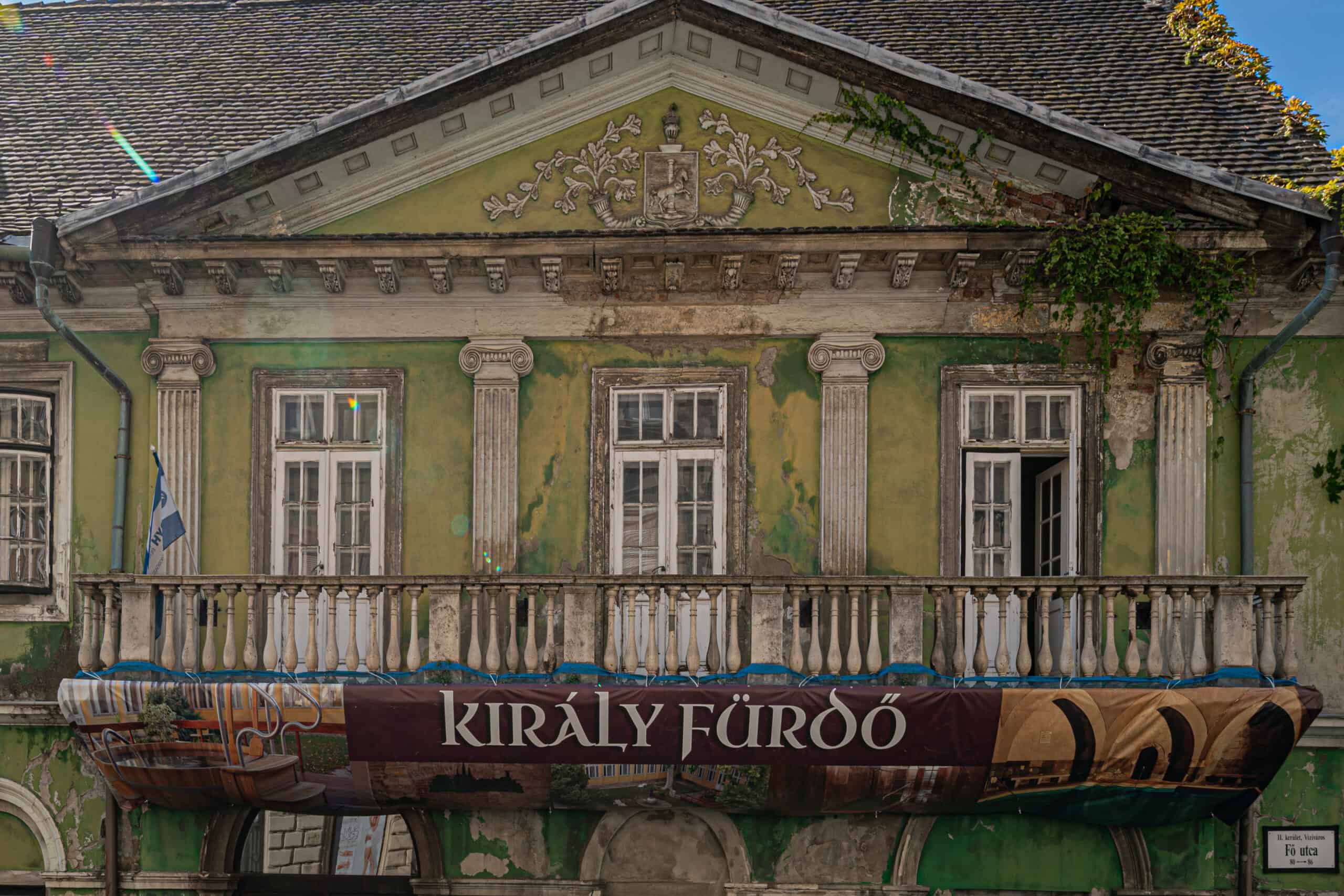 The painted Hungarian sign 'Király Gyógyfürdő' above a thermal bath entrance