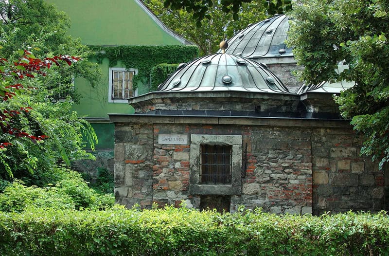 The deeply historic arched stone walkways surrounding the main pool at Király Bath