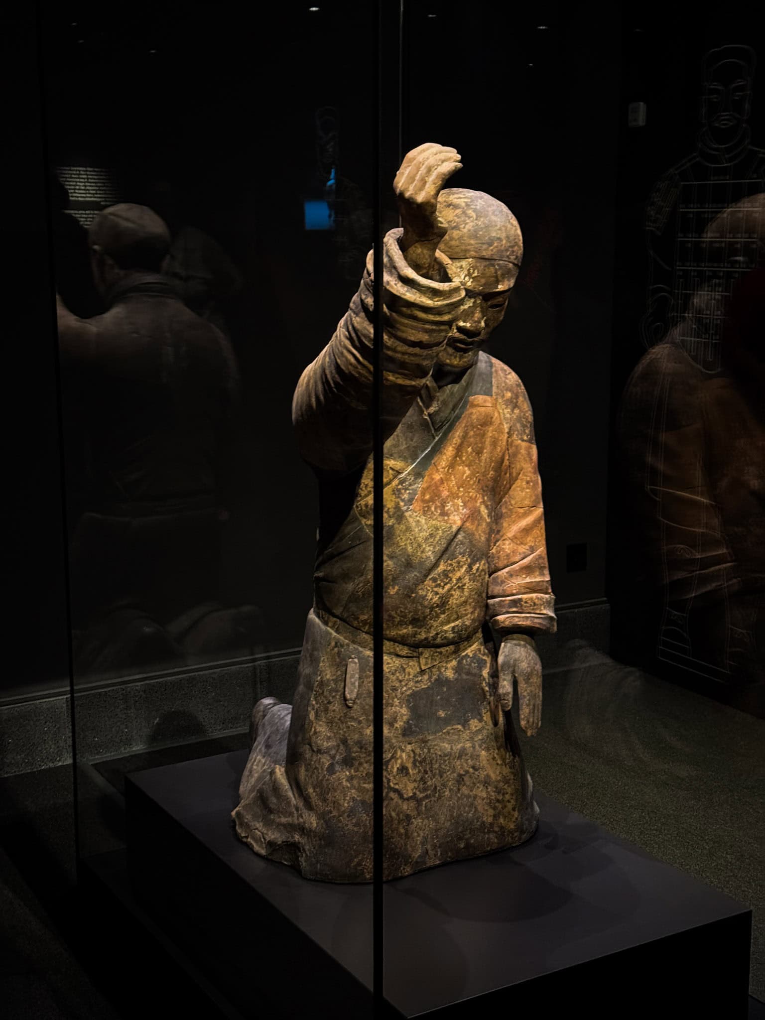A terracotta figure of a kneeling musician