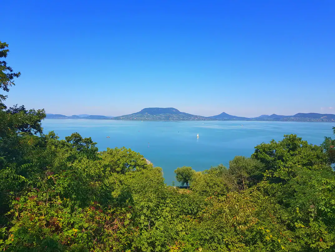 Tourists riding bicycles along a dedicated paved bike path right next to Lake Balaton