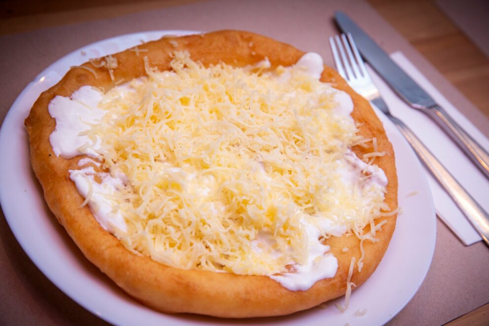 Lángos topped with sour cream and cheese