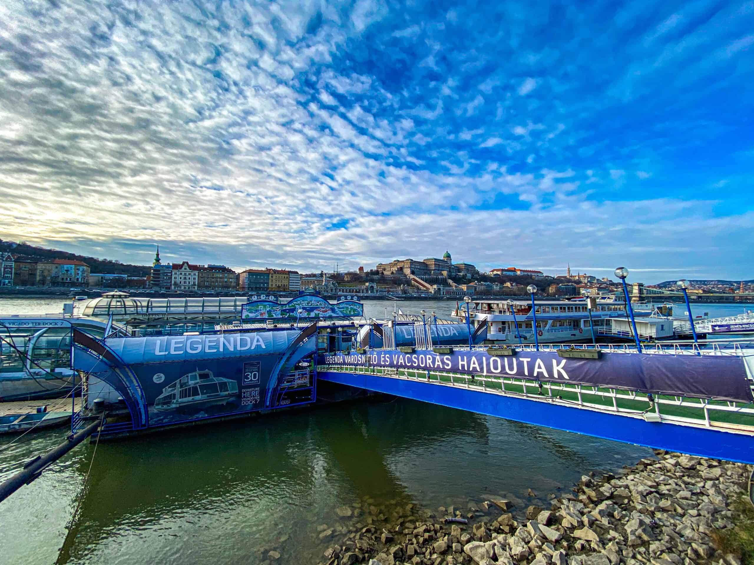 A modern Legenda sightseeing boat gliding across the Danube past the Parliament