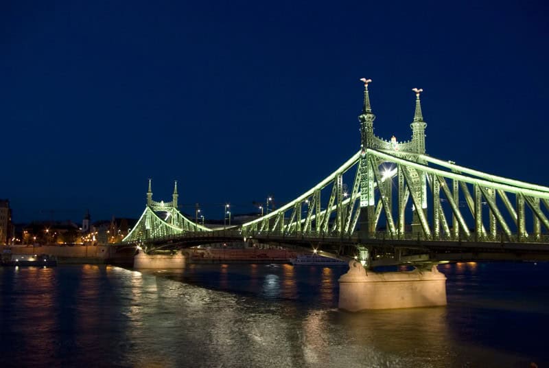 The complex steel webbing completely of Liberty Bridge beautifully illuminated by warm night lights