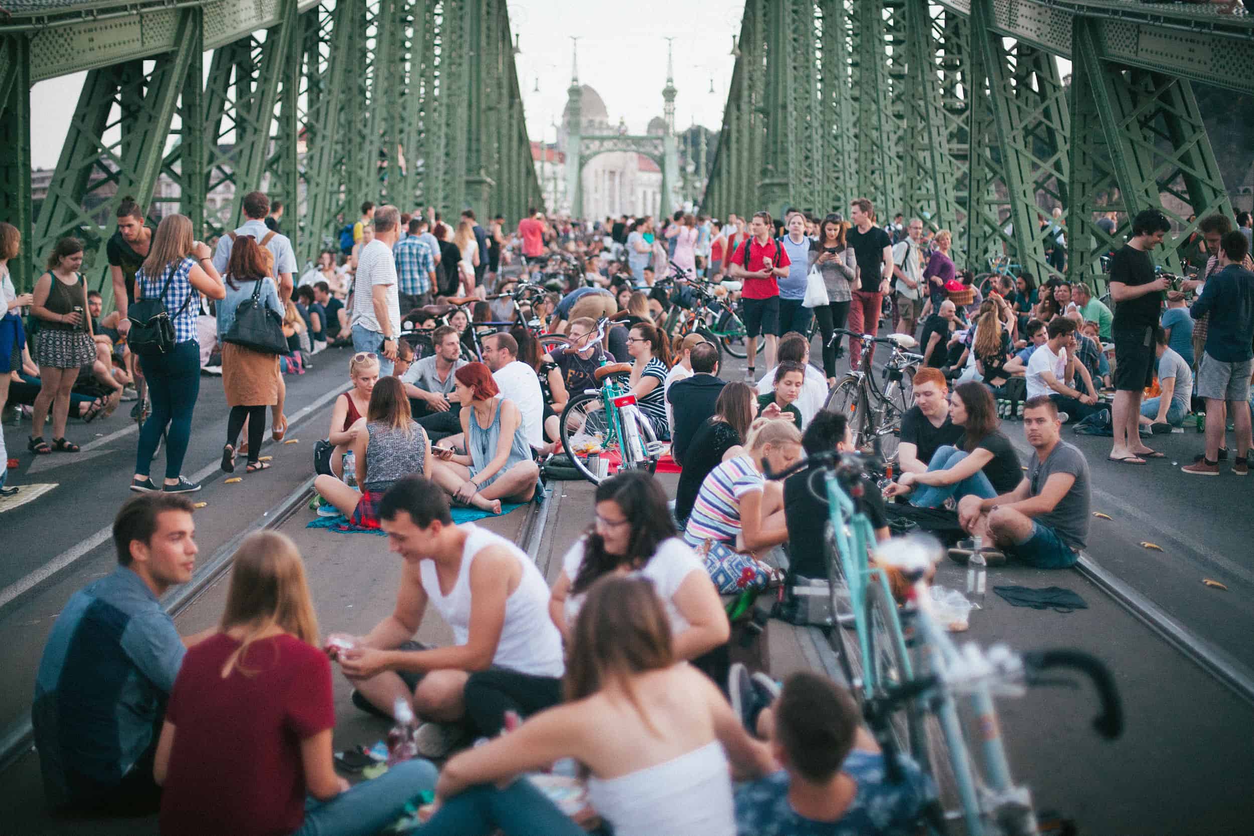 A massive crowd tightly of happy locals fully enjoying a summer outdoor picnic on the bridge