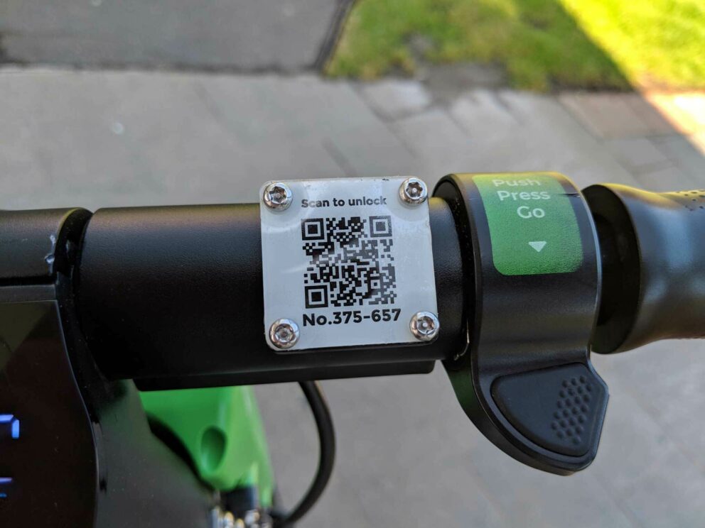 A close up of the QR code and throttle on a Lime scooter
