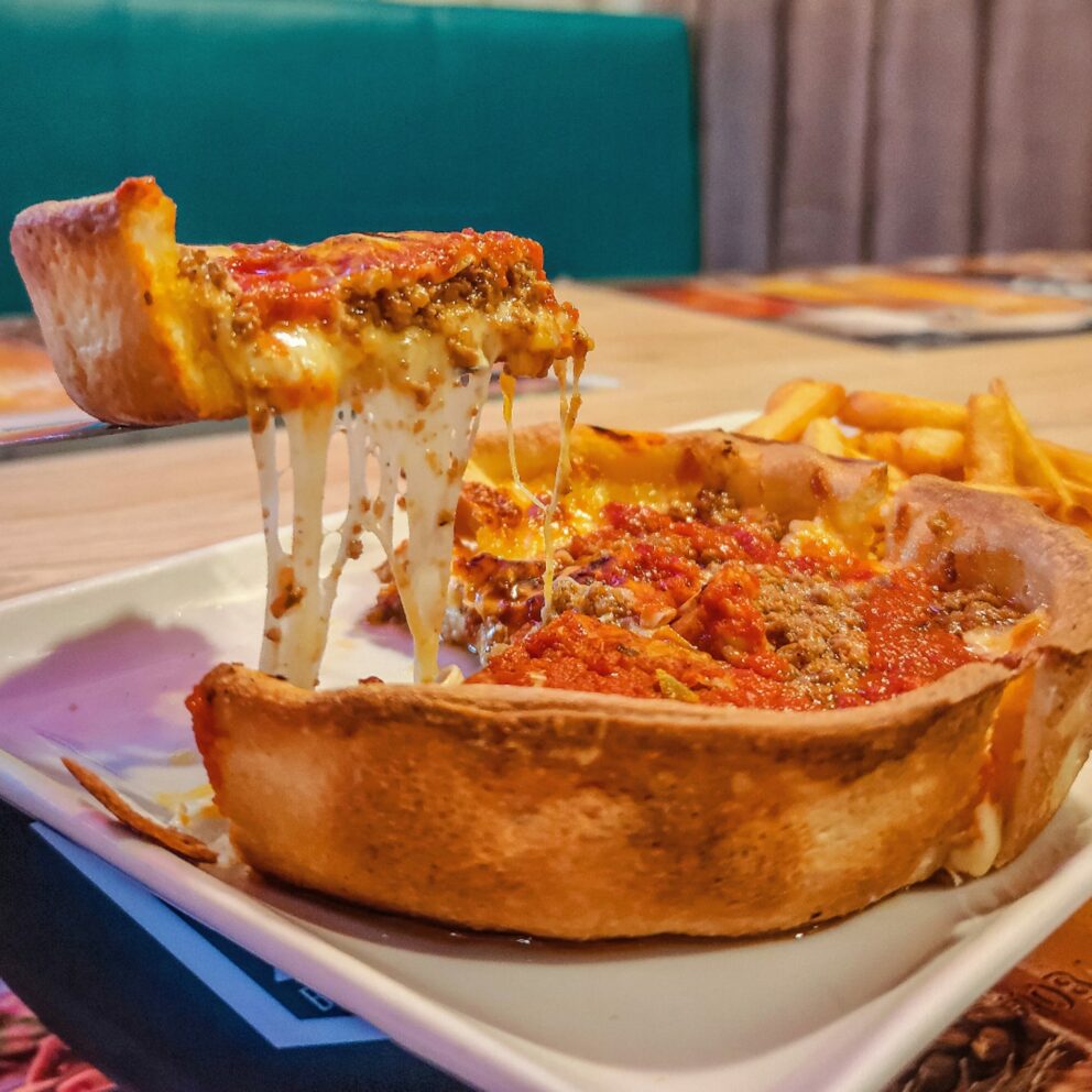 A massive, heavily loaded plate of cheesy nachos topped with jalapeños