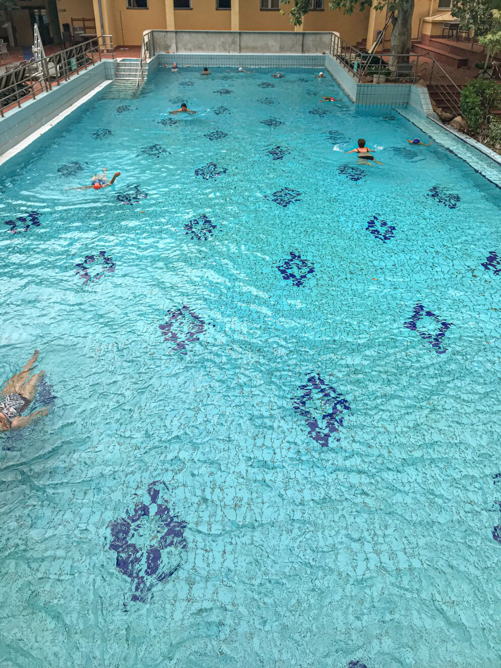 Strictly marked athletic swimming lanes securely roped off inside the outdoor blue pool.