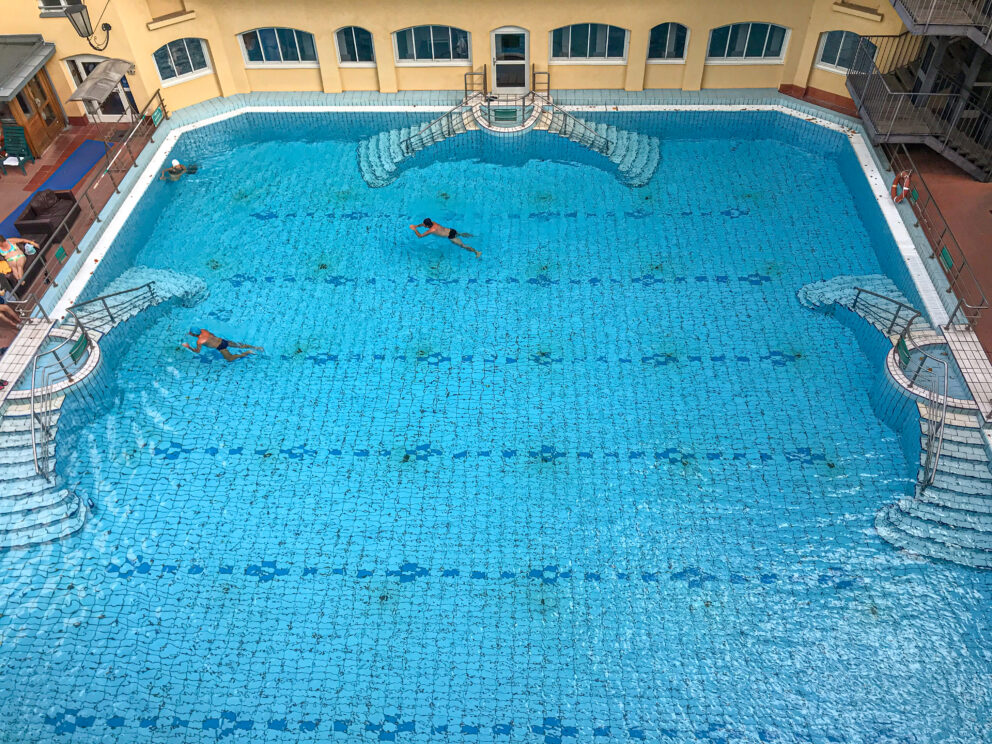 Rows of identical beige plastic sun loungers lined up on the rooftop wooden terrace.
