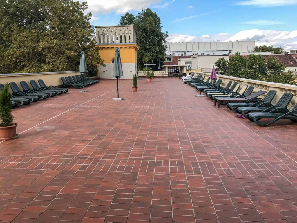 A massive elevated wooden rooftop sun terrace actively packed fully with sunbathing locals