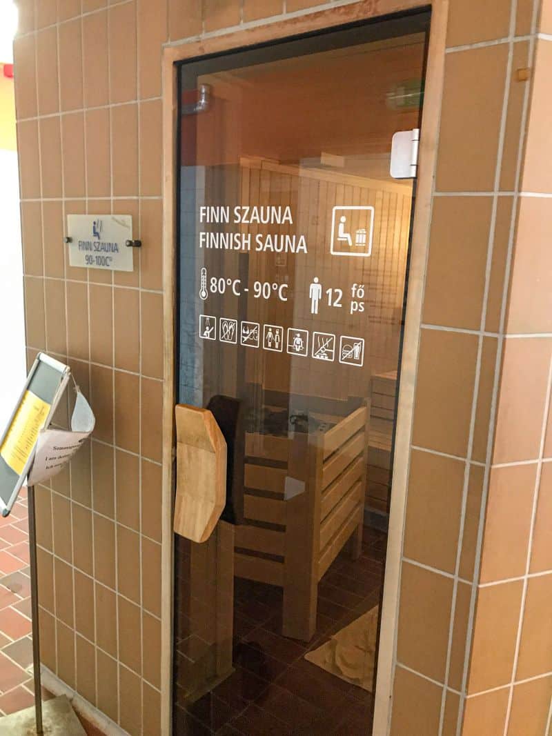 The warm wooden paneling and spacious multi-level seating directly inside a massive Finnish sauna