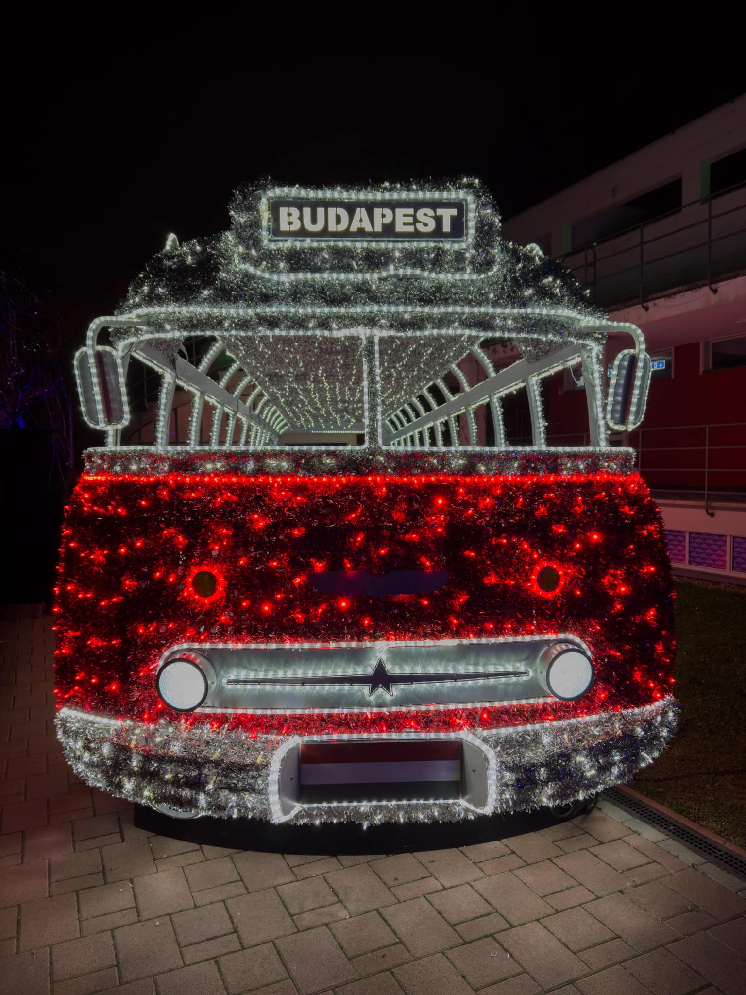 A life-sized illuminated vintage double decker bus entirely painted bright red
