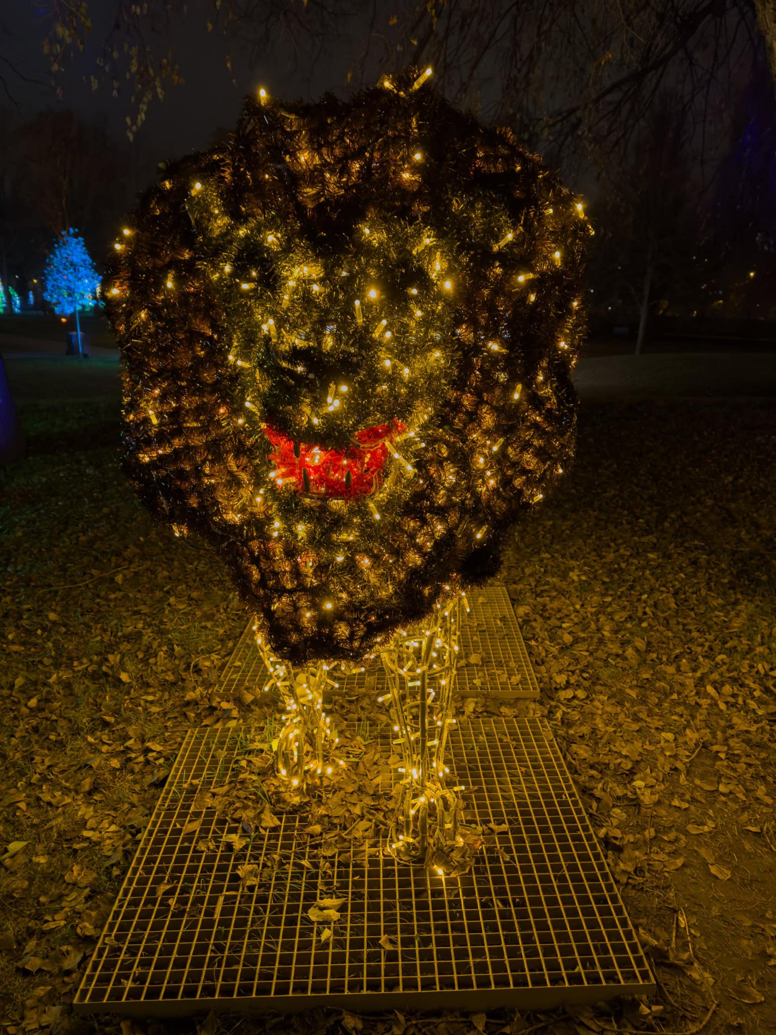 A majestic glowing golden lion head radiating light as the park centerpiece