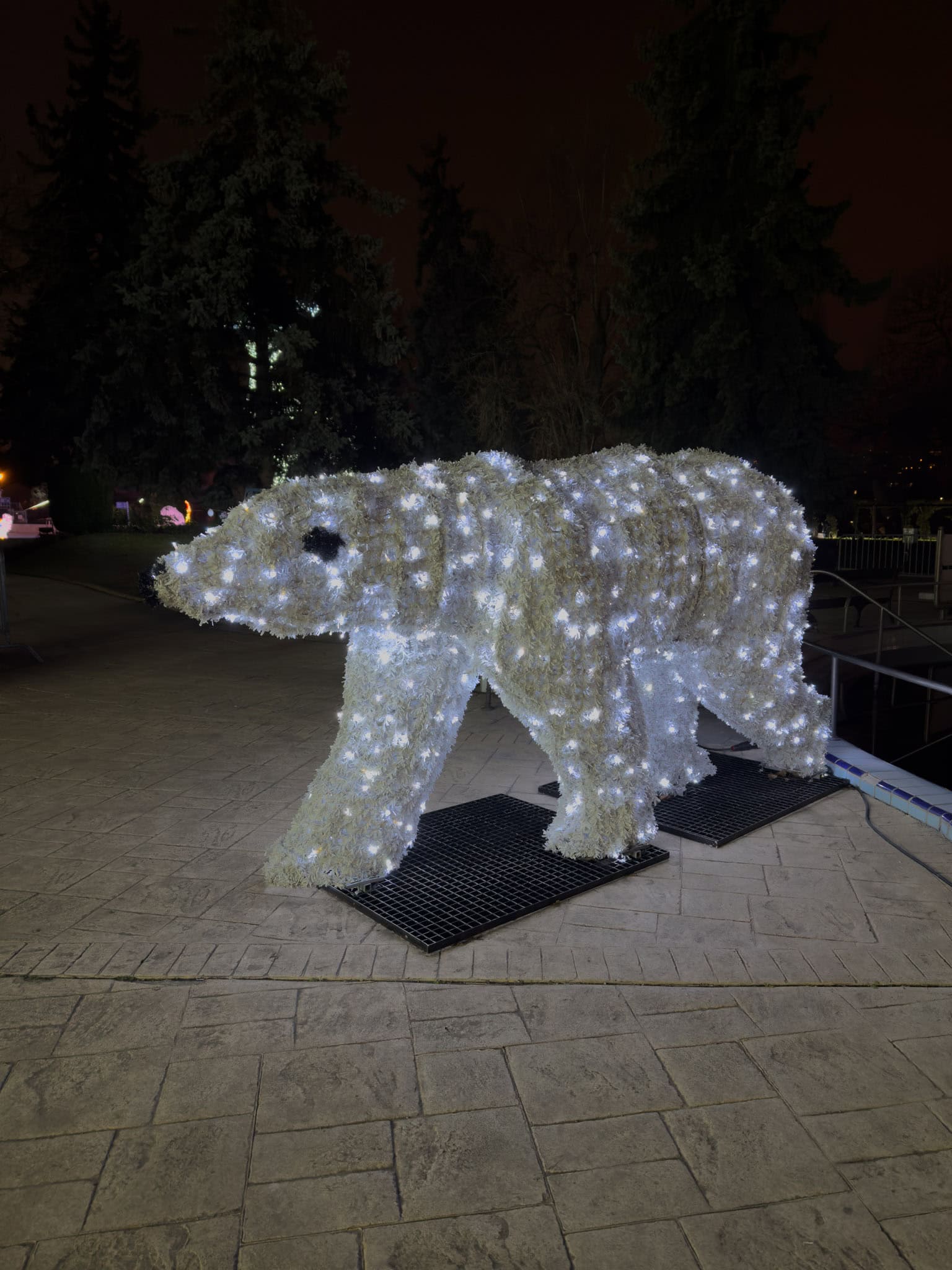 Glowing white polar bear light sculptures standing firmly on artificial icy platforms