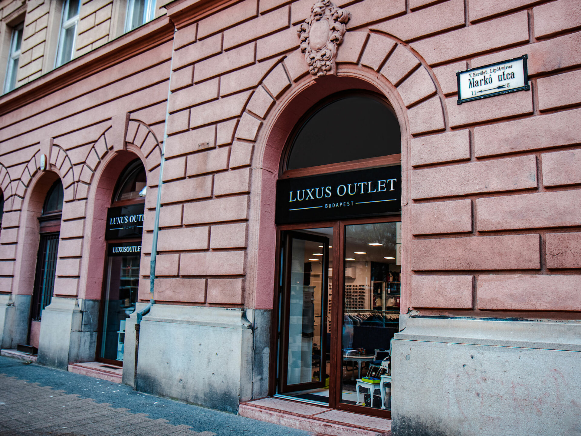 The elegant exterior storefront of a high-end luxury brand boutique inside the outlet mall
