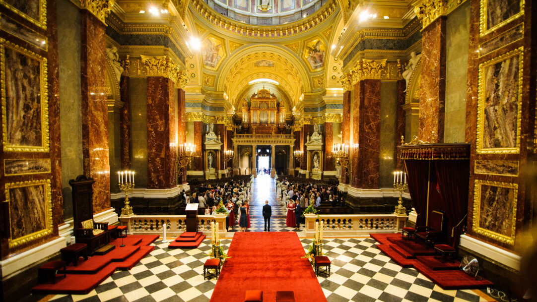 An elegant wedding ceremony set up inside the opulent Golden interior of the Basilica