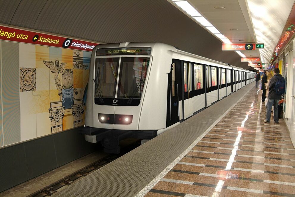 A modern red and white Alstom train on the M2 metro line in Budapest