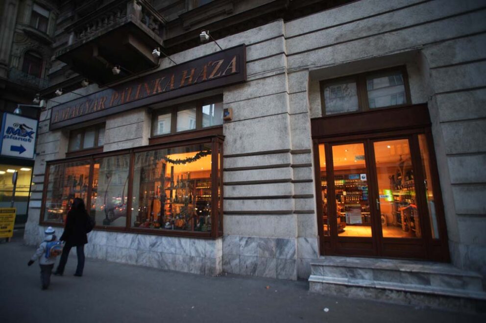 The exterior of A Magyar Palinka Haza shop showing large windows displaying bottles