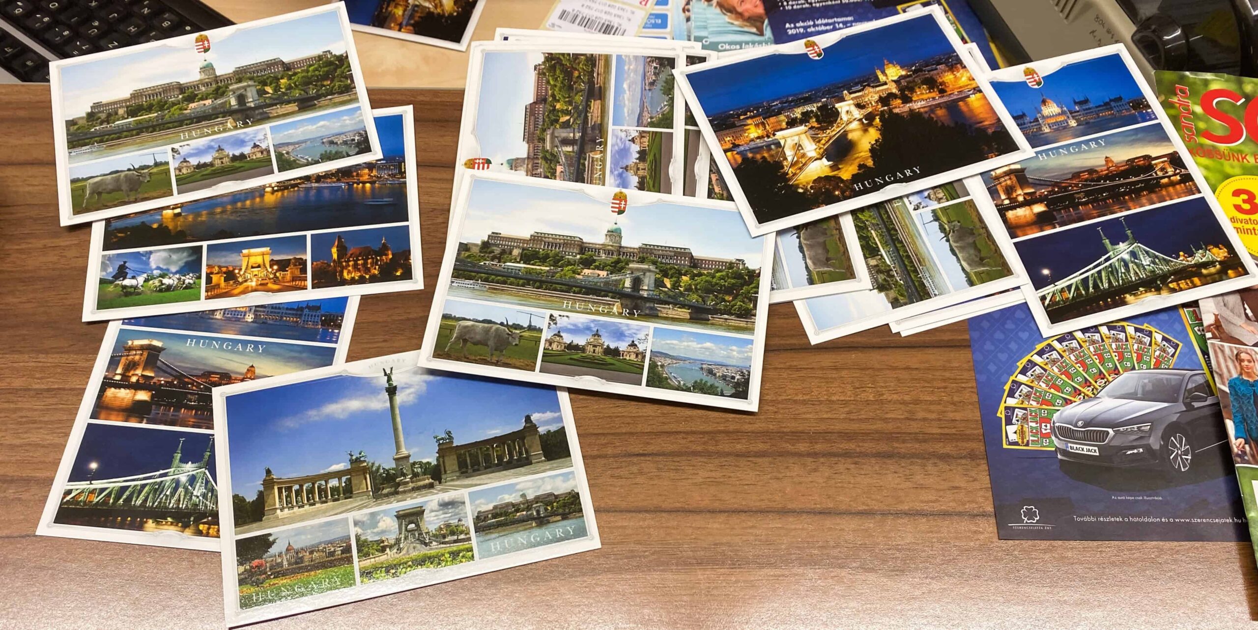 A green and red Magyar Posta sign hanging on a building
