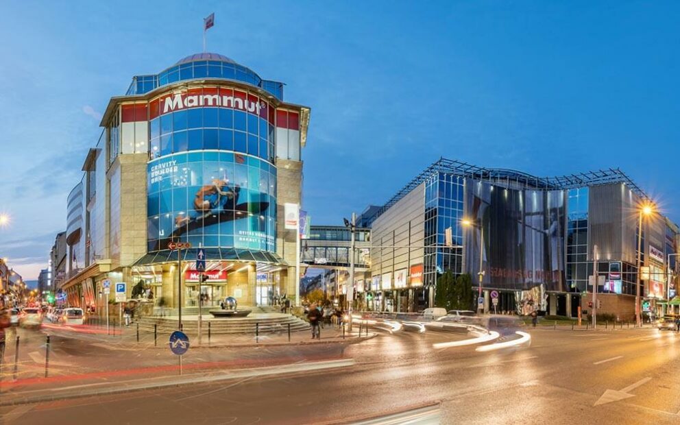 The safely bustling modern outdoor plaza beautifully situated underneath the towering facade