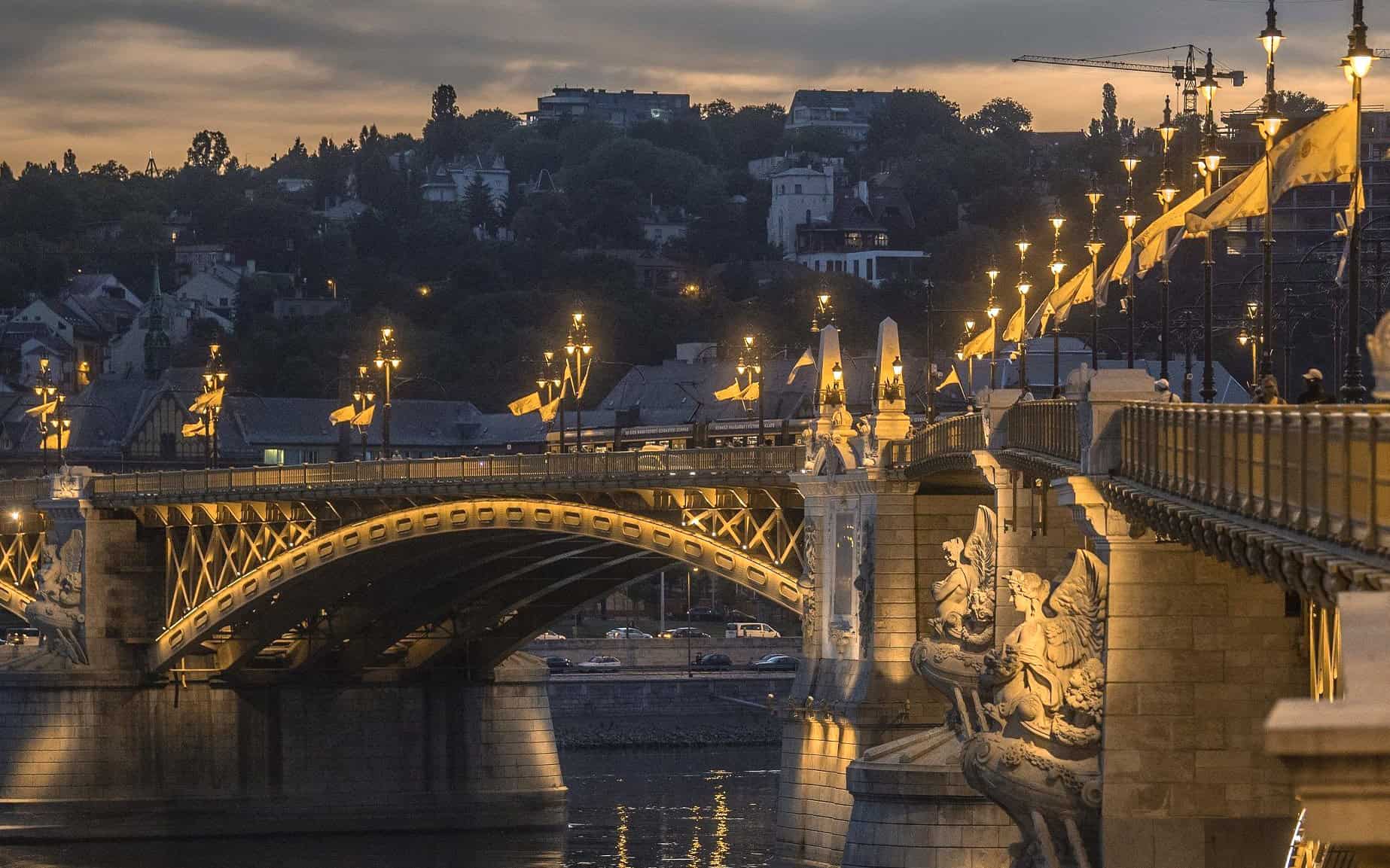 Massive stone bridge support pillars neatly topped securely with brightly gilded Hungarian Crown sculptures